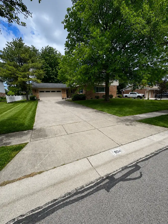 Mowed front lawn on both sides of a residential driveway